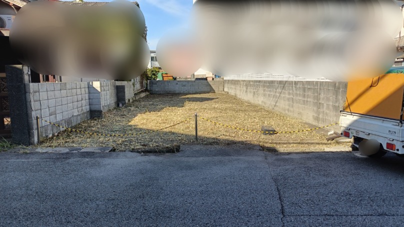 道路側から見た草刈り後の空き地全景と軽トラック 